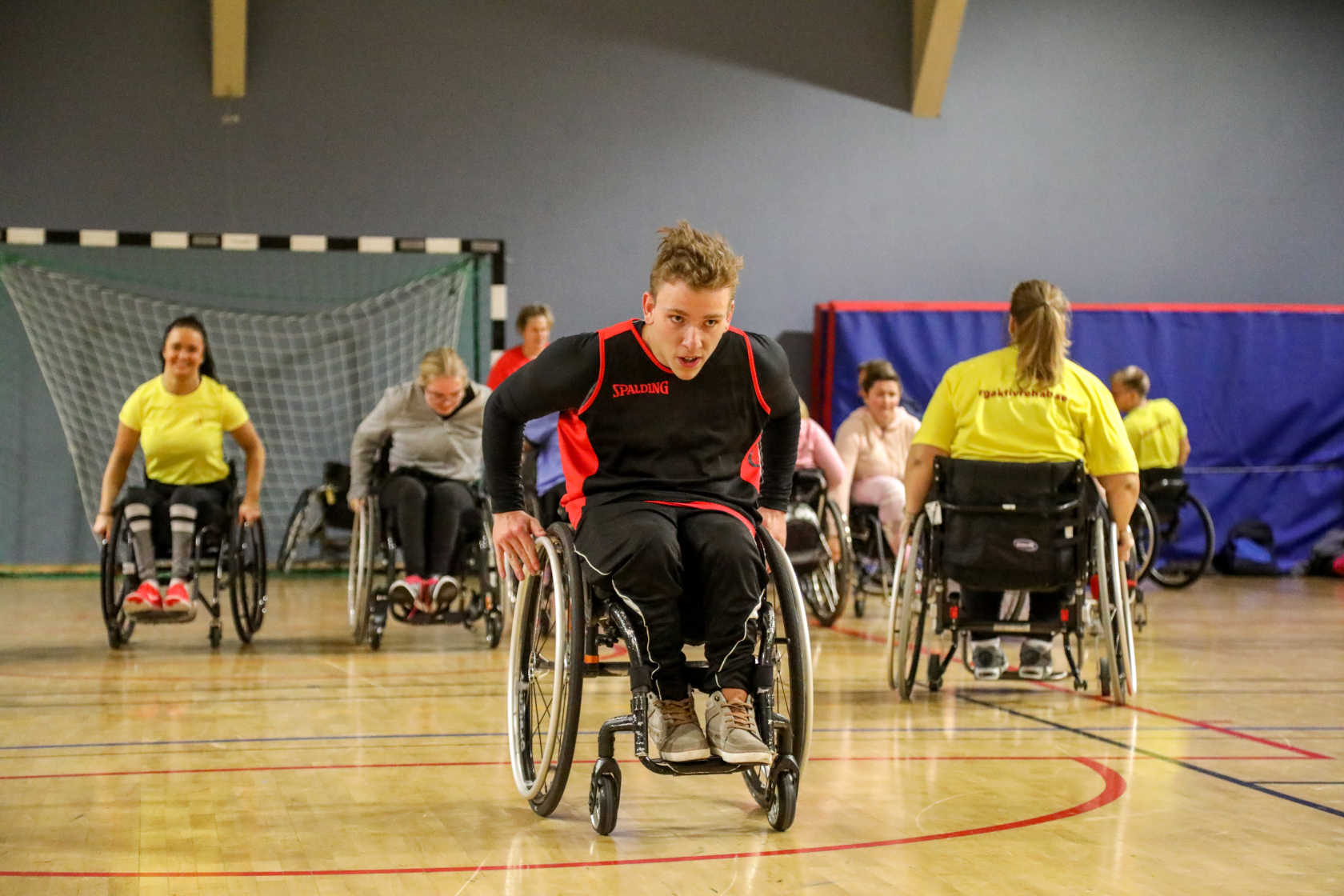 En grupp personer i rullstol tränar sina rullstolsfärdigheter.