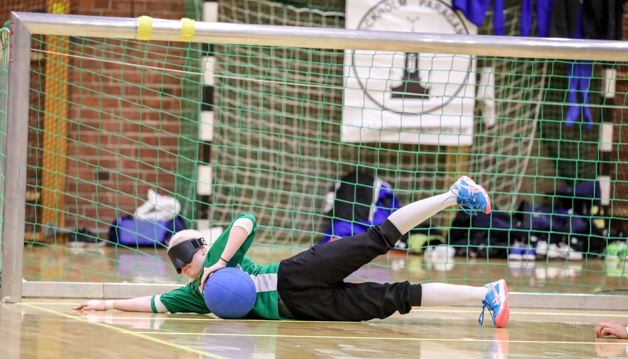 Goalbollspelare fångar ett skott.