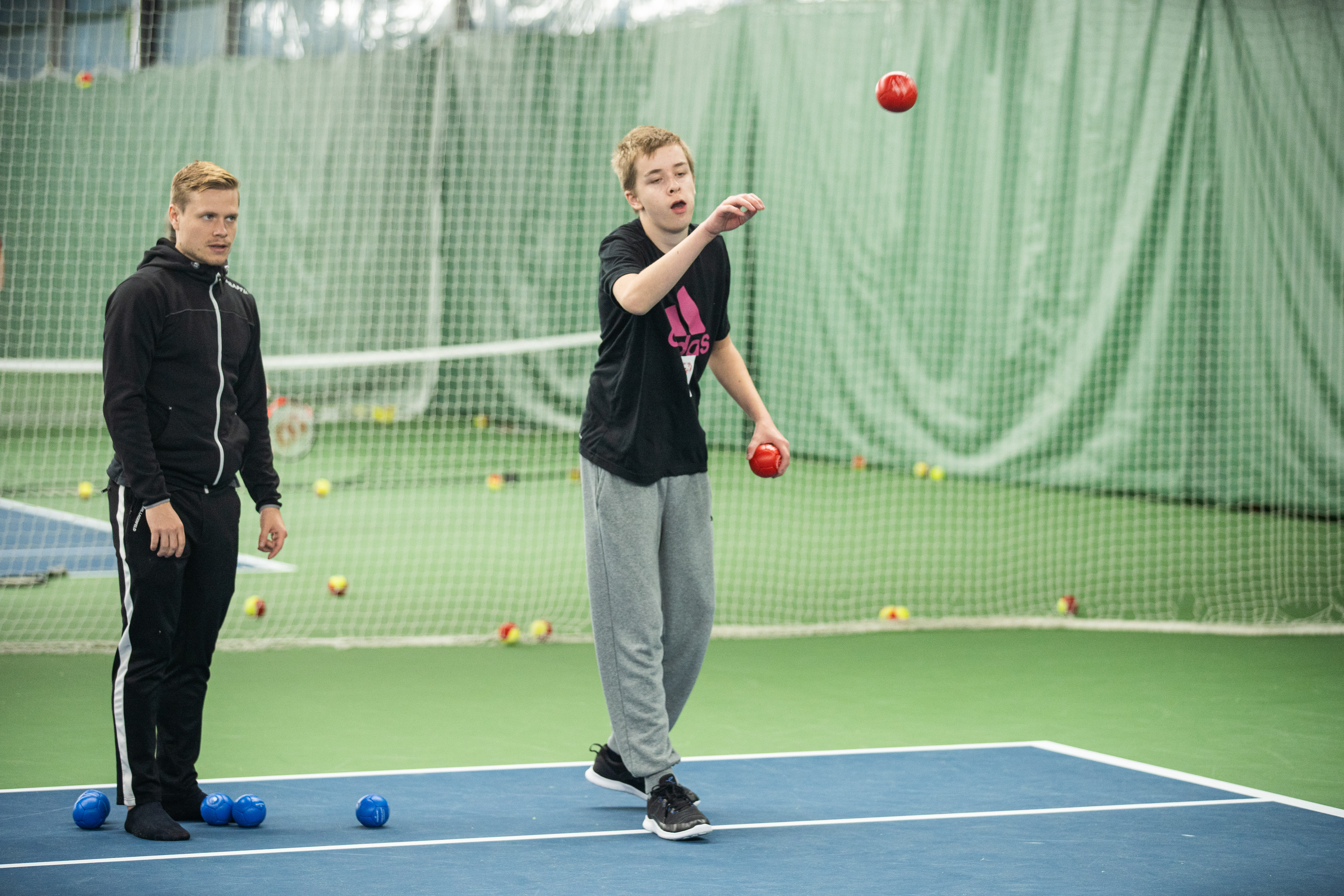 Kille har precis kastat ett rött bocciaklot.