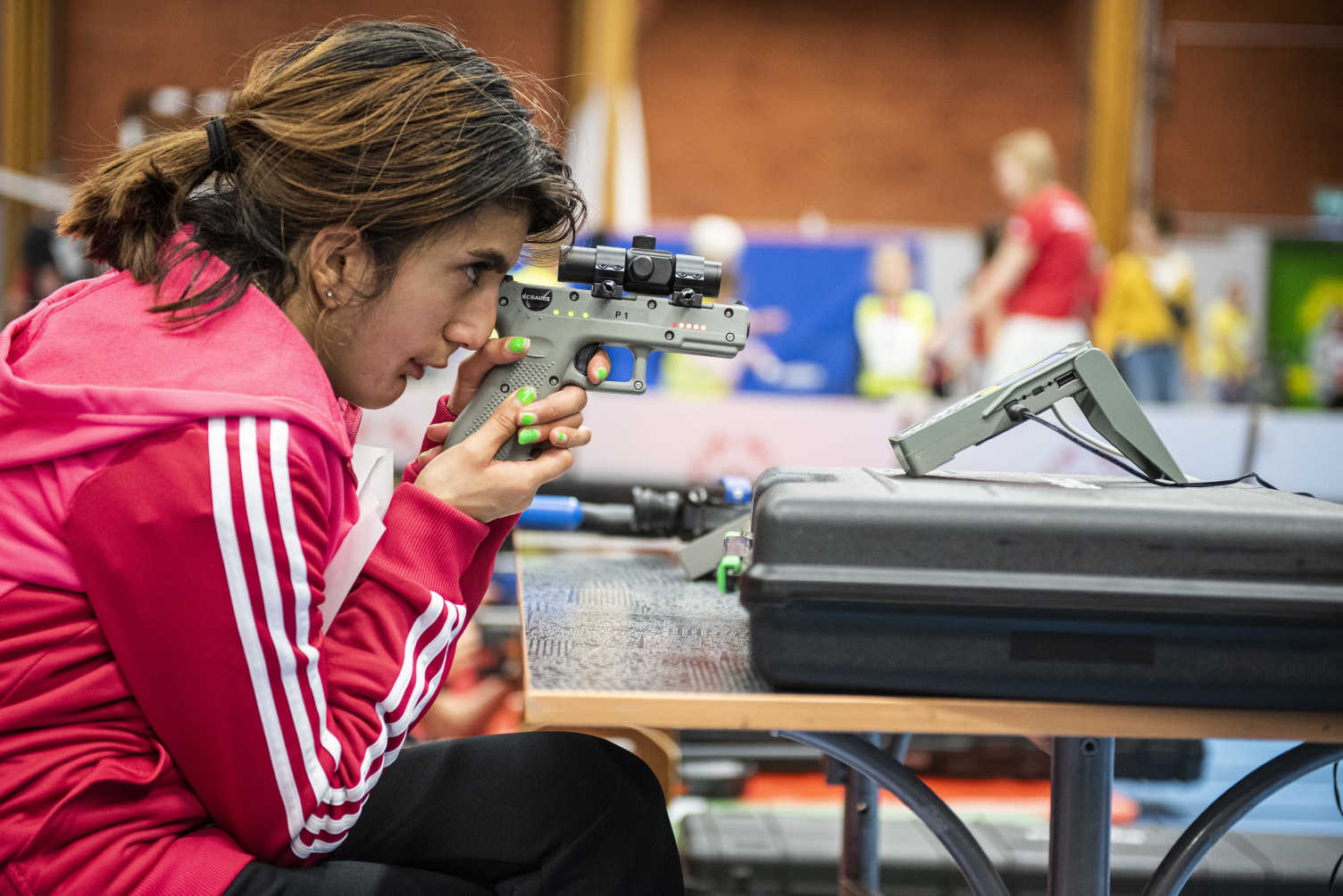 En tjej gör sig redo för att skjuta med en pistol.