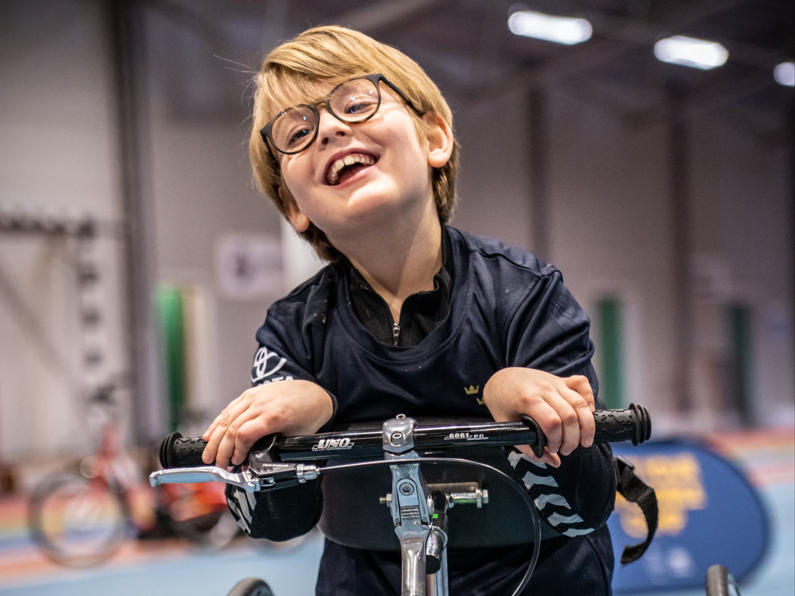 Ett glatt barn tar sig framåt på en framerunningcykel.