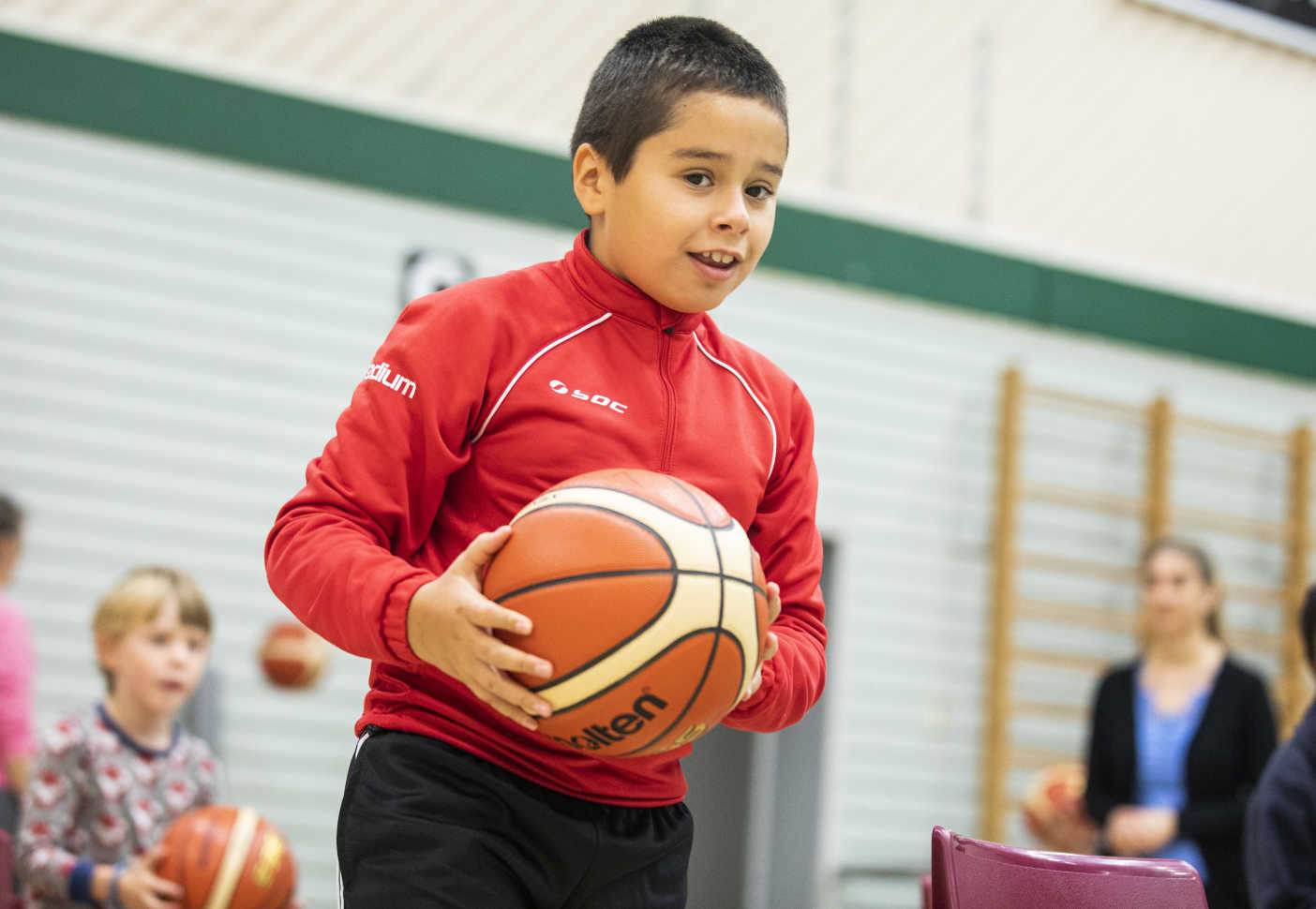 En pojke håller i en basketboll.