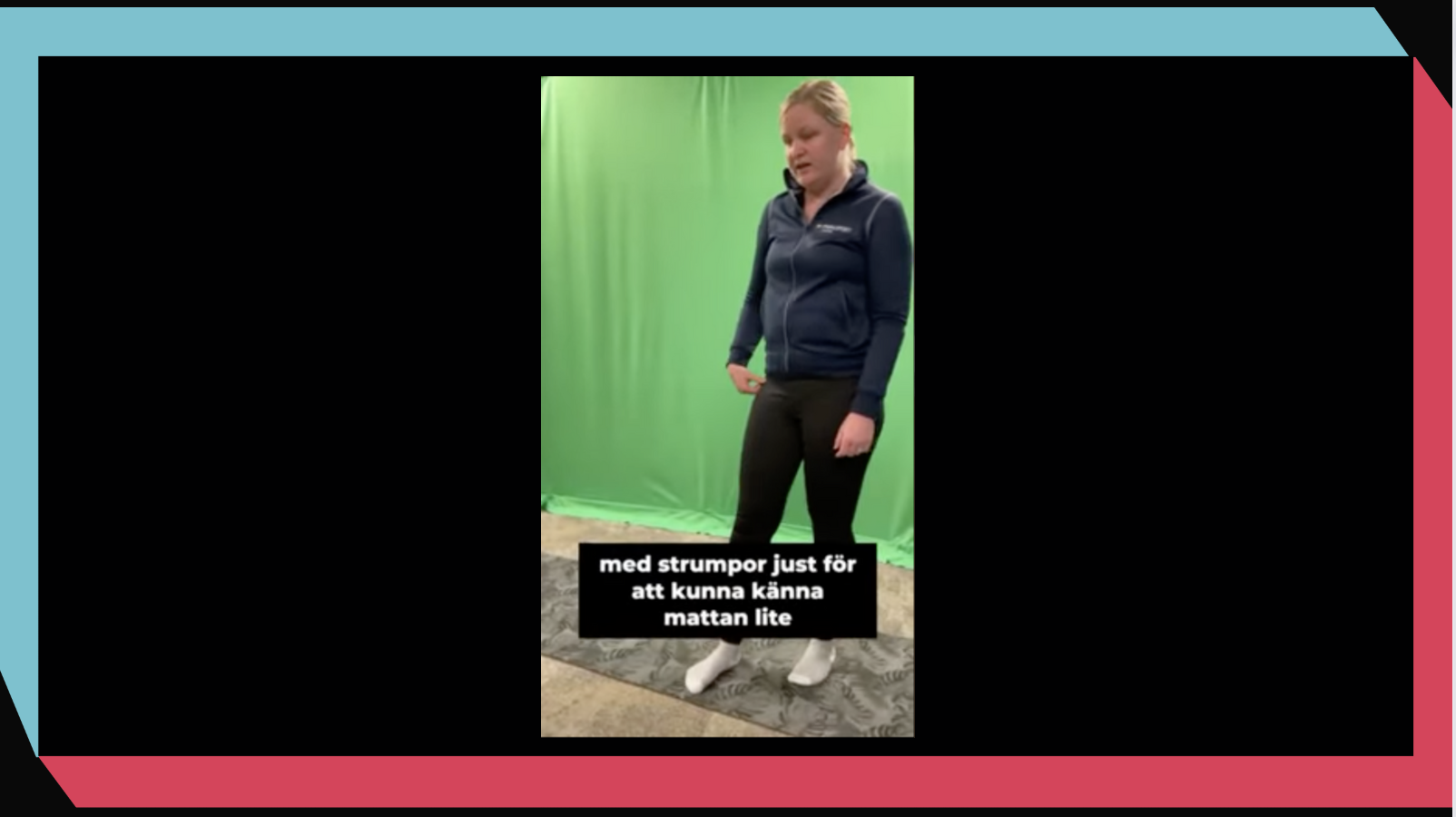 Skärmavbild från videon om hur du kan navigera med hjälp av en yogamatta om du har synnedsättning. På bilden är det Josefin som står i strumpor på en yogamatta i ett rum med grön duk på väggen. 