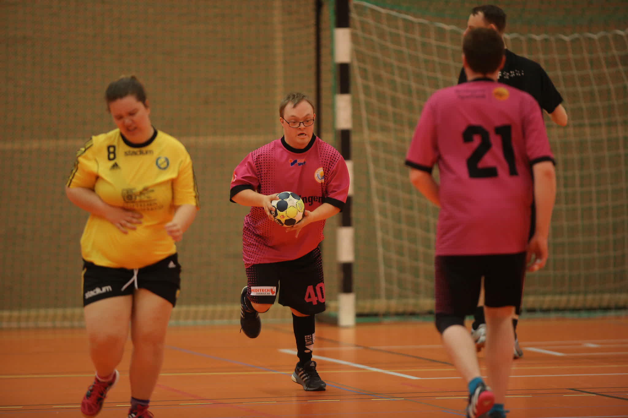 Handbollsmatch där spelare springer med bollen. 