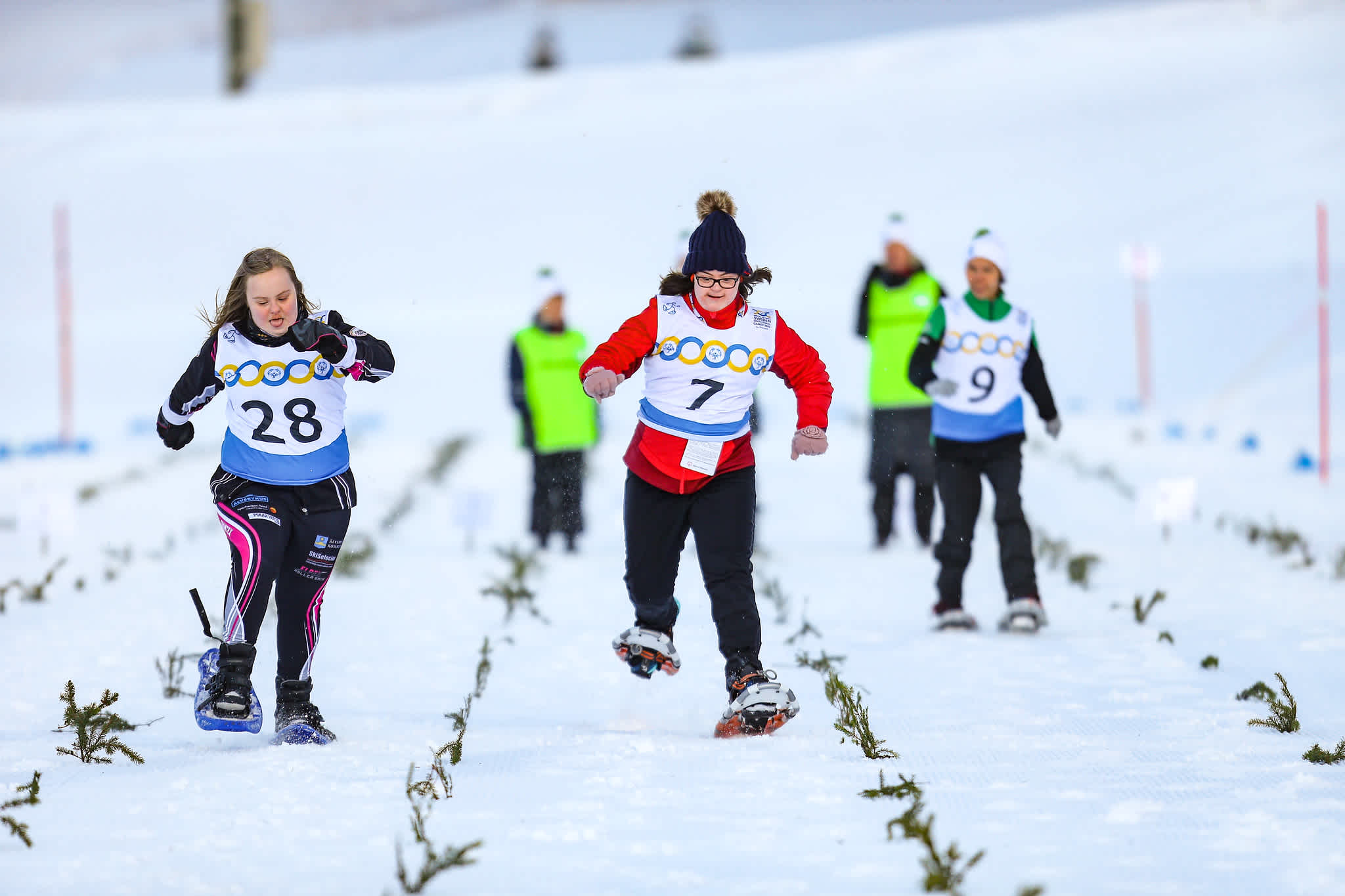 Deltagare i snöskolöpning springer mot varandra i ett 25-meterslopp.