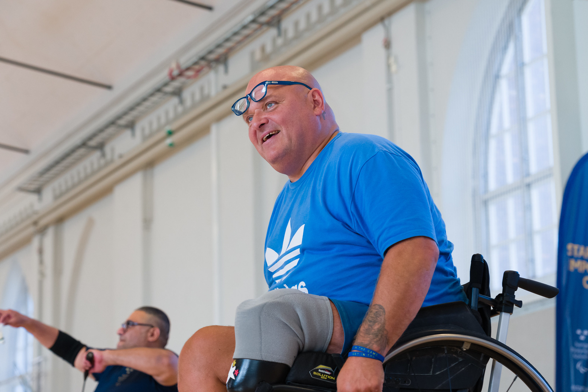 Niclas i blå t-shirts ler när han spelar badminton.