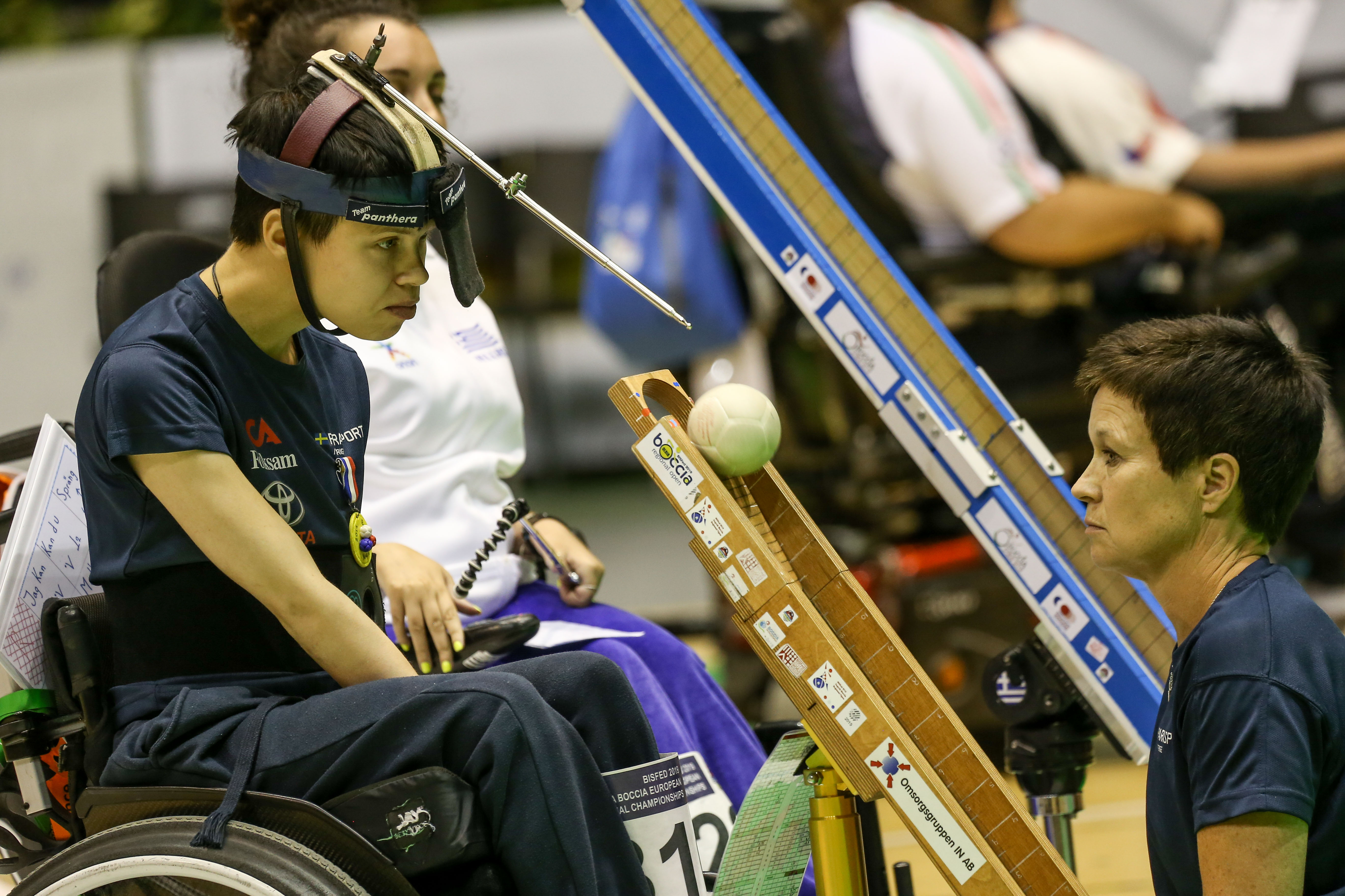 Maria under en match i boccia. Hon släpper en boll i rännan.