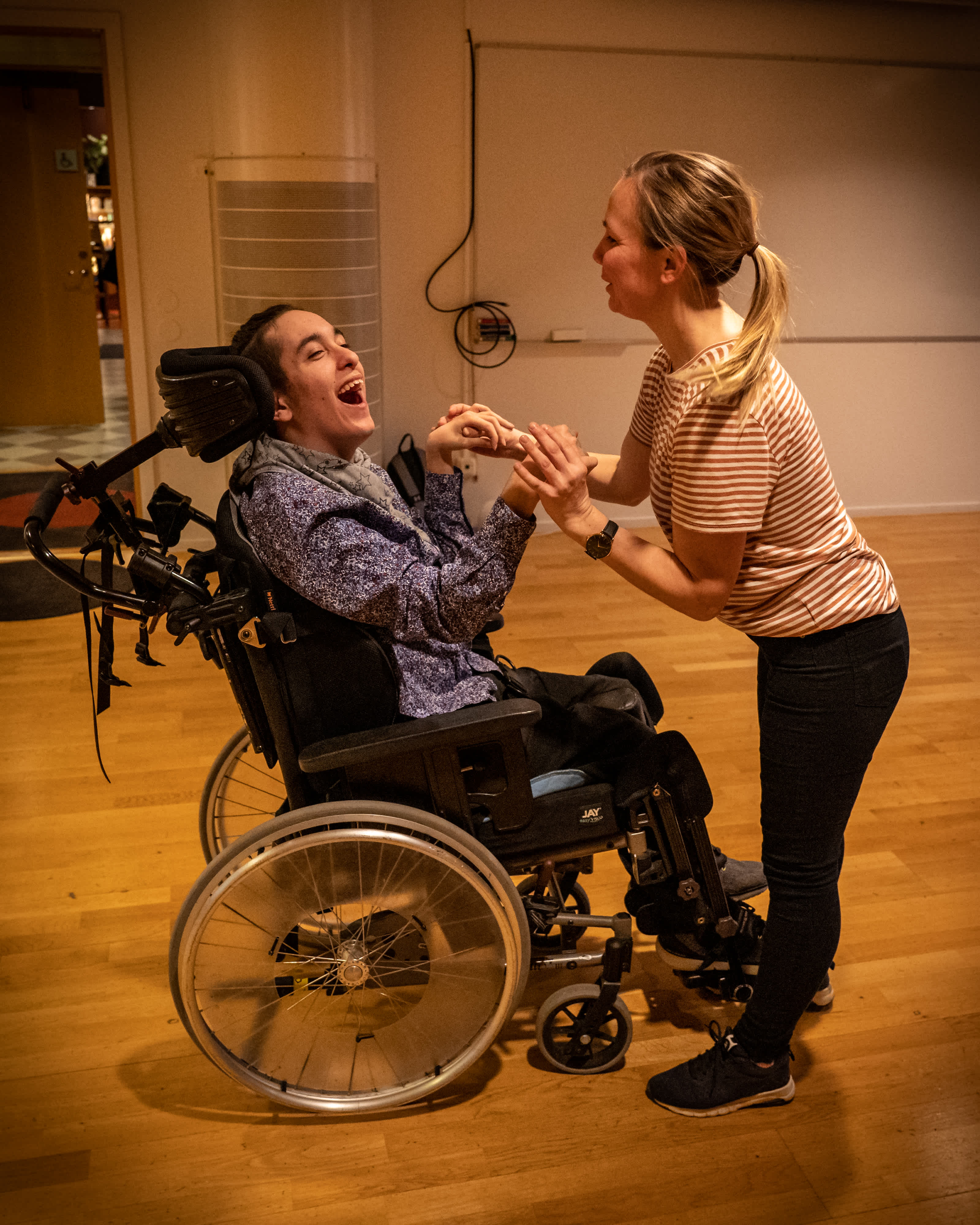En person i rullstol dansar med en person utan rullstol.