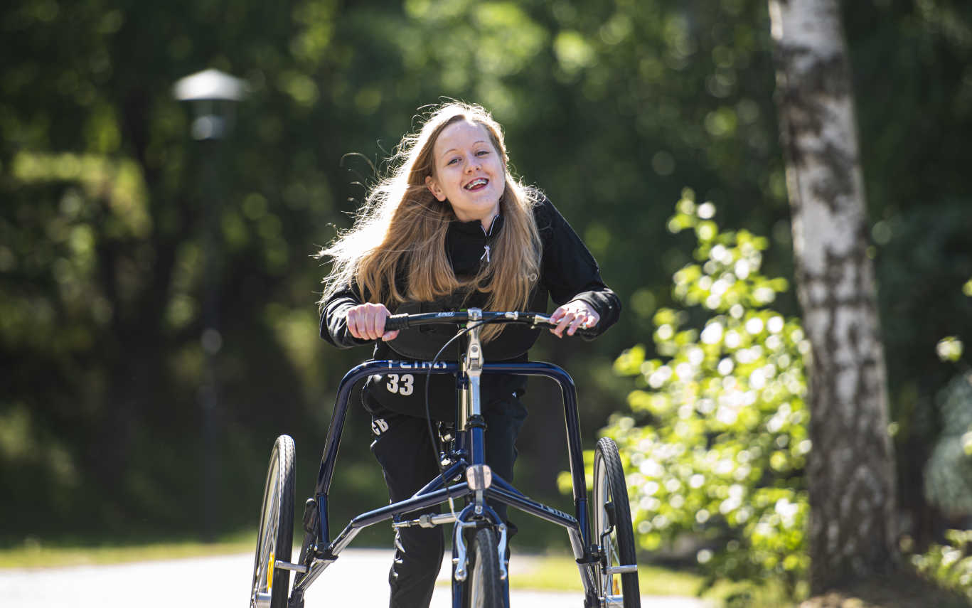 En tjej tar sig framåt på en framerunningcykel utomhus.