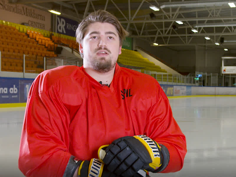 Max Gyllsten blir intervjuad. Han har en röd tröja och svarta hockeyhandskar.