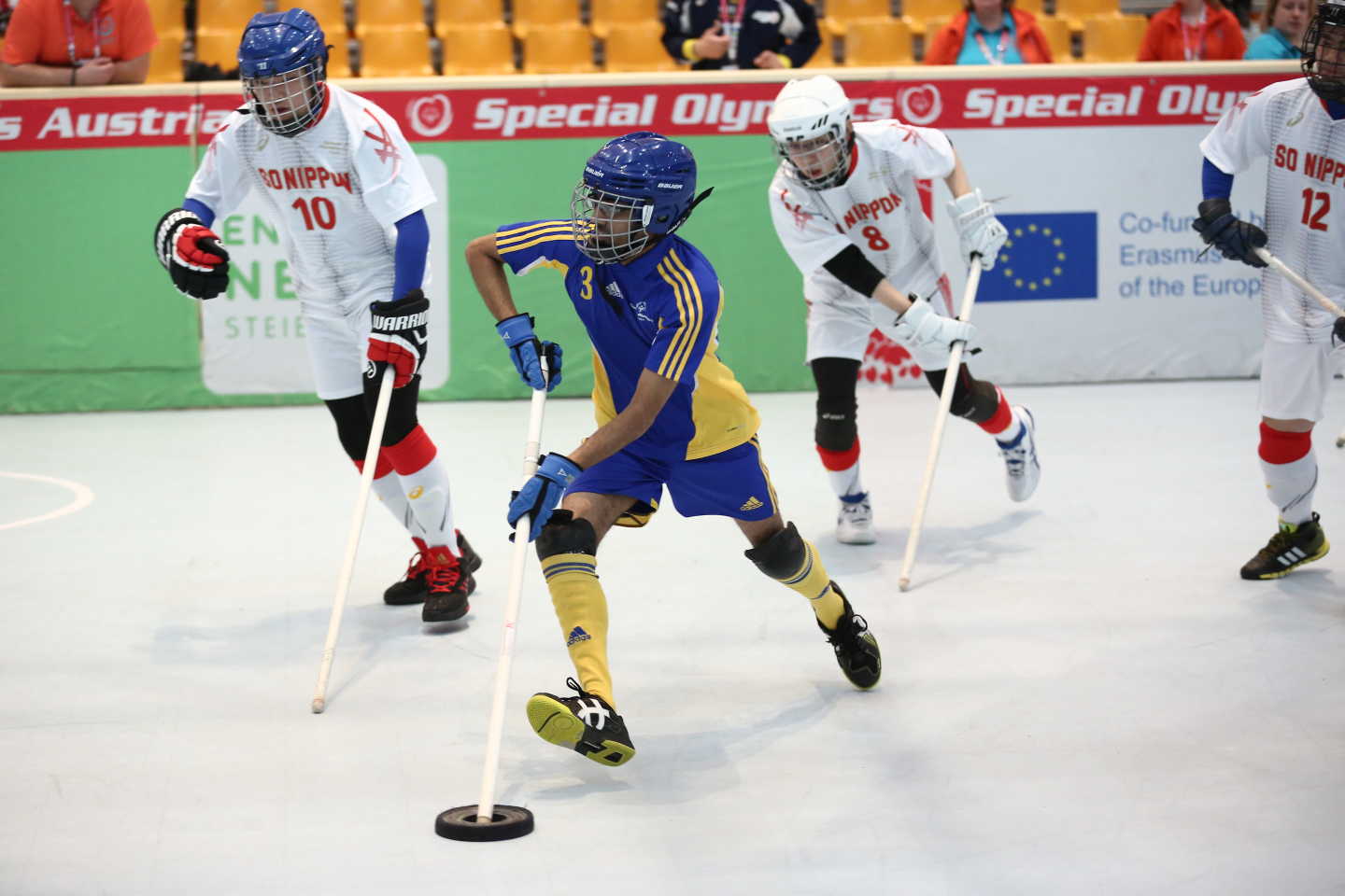 En spelare springer med pucken mot målet och blir jagad av flera motståndarspelare.