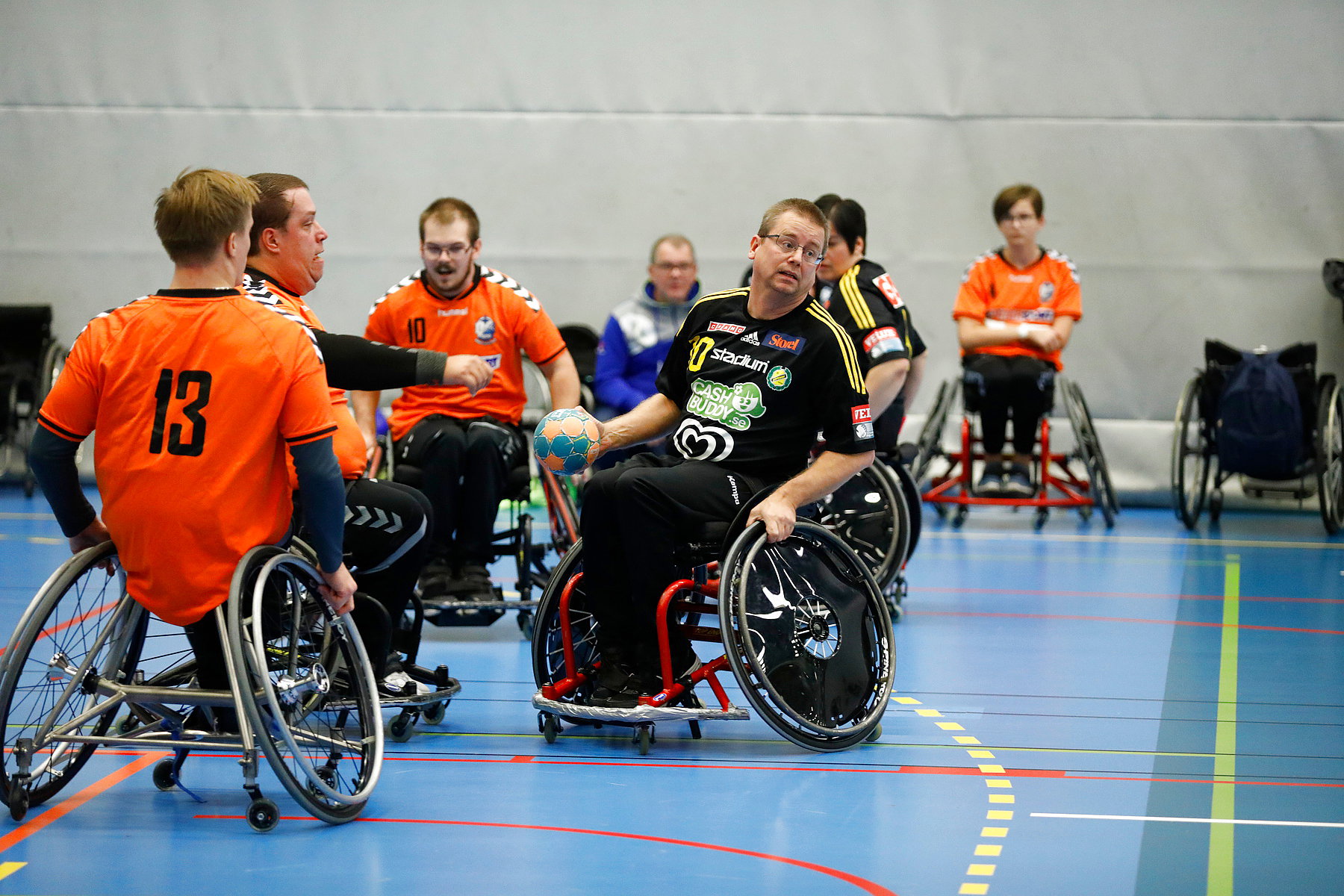 En person har bollen och vänder sig åt sidan för att skjuta. Flera motståndare finns runt omkring.