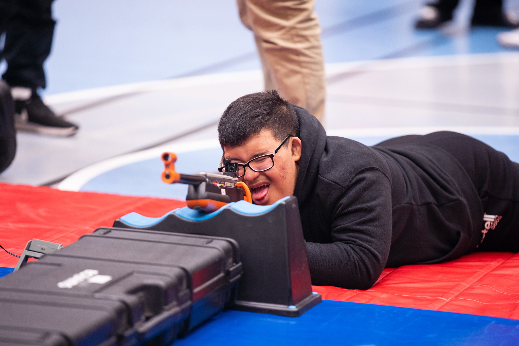 Kille siktar in sig på tavlan i liggande sportskytte.