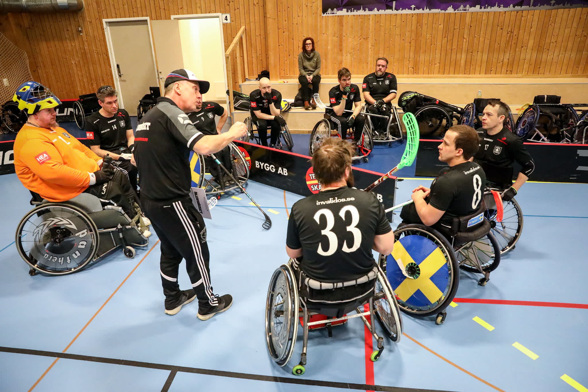 En ledare instruerar spelare under en match i rullstolsinnebandy.