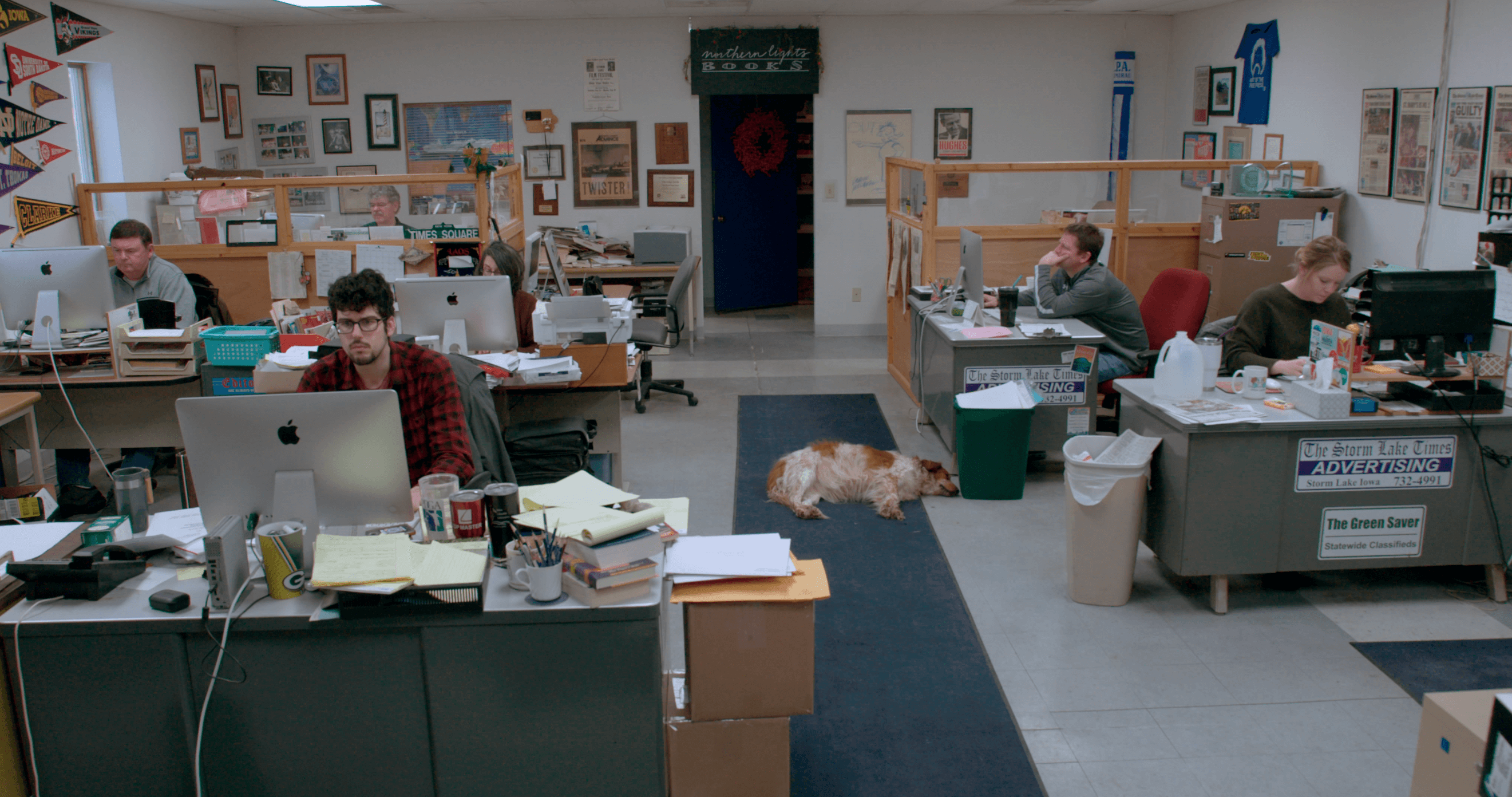 Still from Storm Lake. The team works in the newsroom.