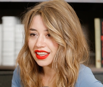 Portrait of a woman with long hair, smiling and looking to something out of frame to her right