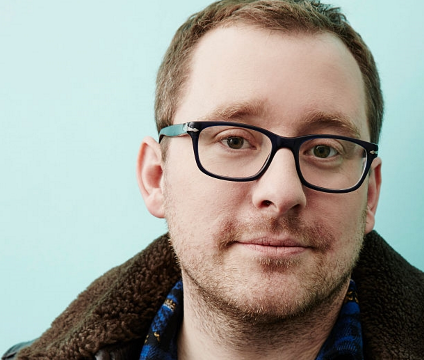 A portrait of a man wearing glasses and looking into the camera.