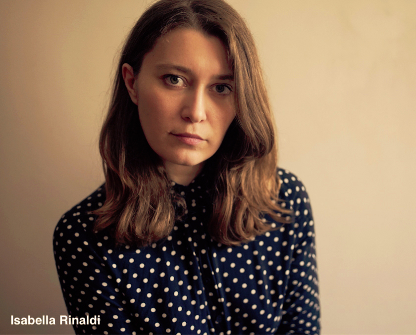 Headshot of a woman in her 30s wearing a blue polka dot shirt against a neutral background.