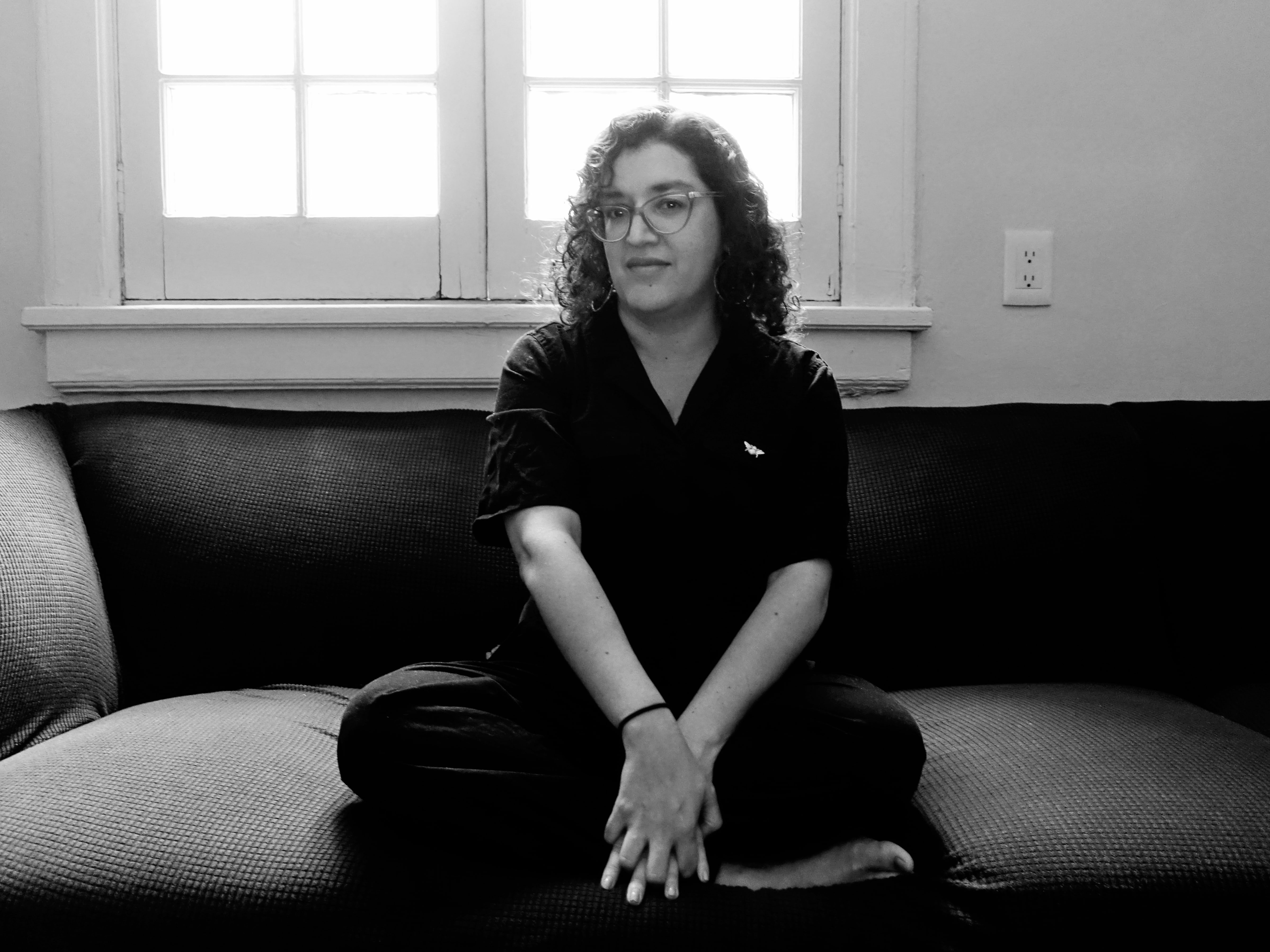 Portrait of a woman with medium long curly hair and frame glasses