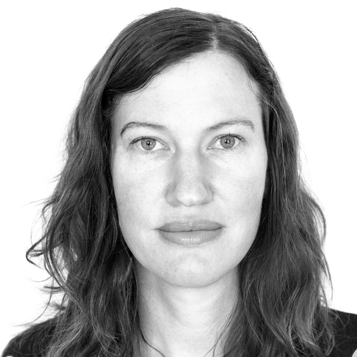 Headshot of a woman looking directly at the camera, her medium length hair is parted on the left