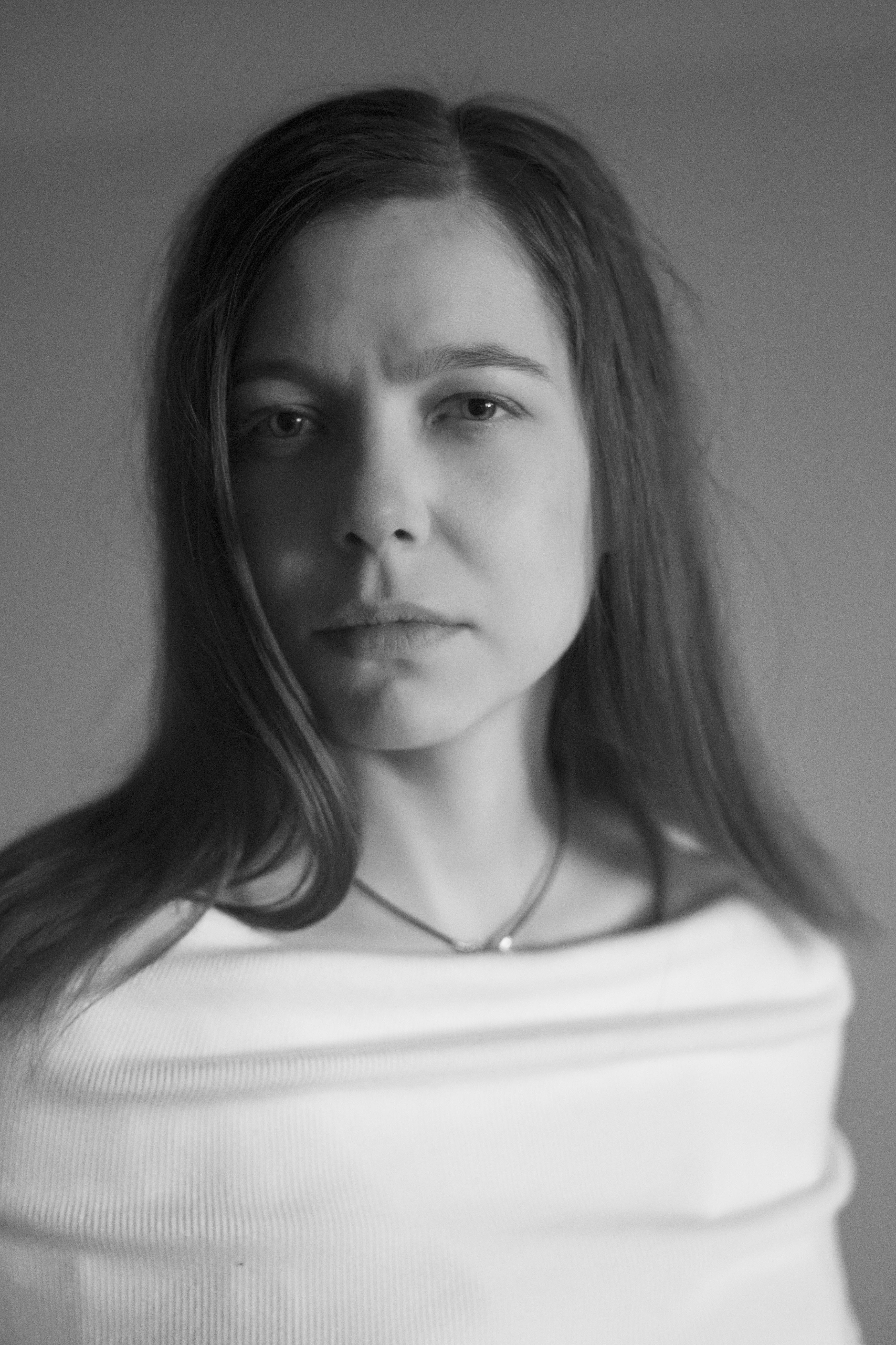 Black and white headshot of Zofia Pregowska from the chest up with a neutral expression and furrowed brows.