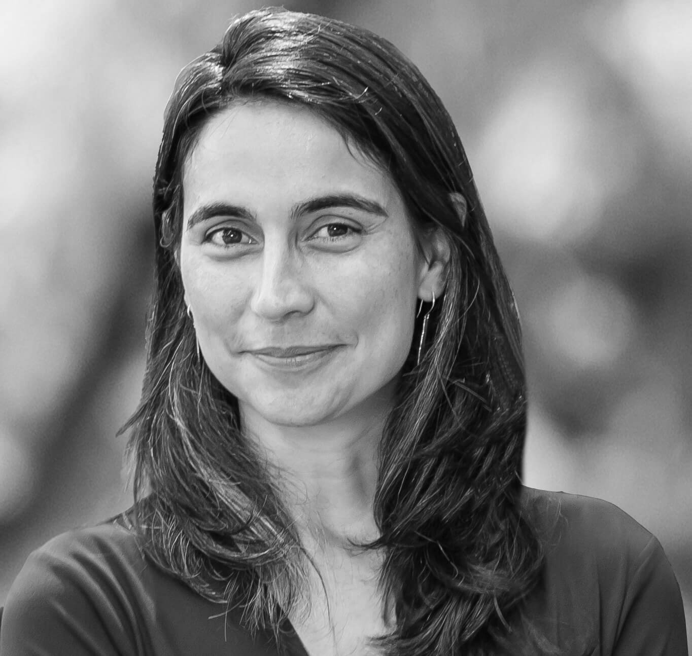 Julia Bacha slightly smiles and has medium-length hair. Black and white portrait.