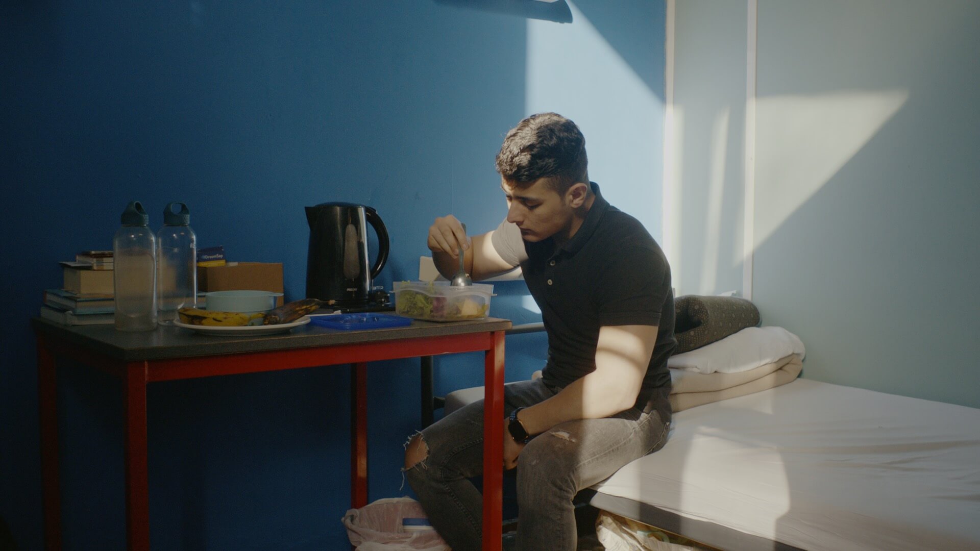 We see a young man (Sajid Khan) on his bed, in the sunlight, eating a meal by himself.