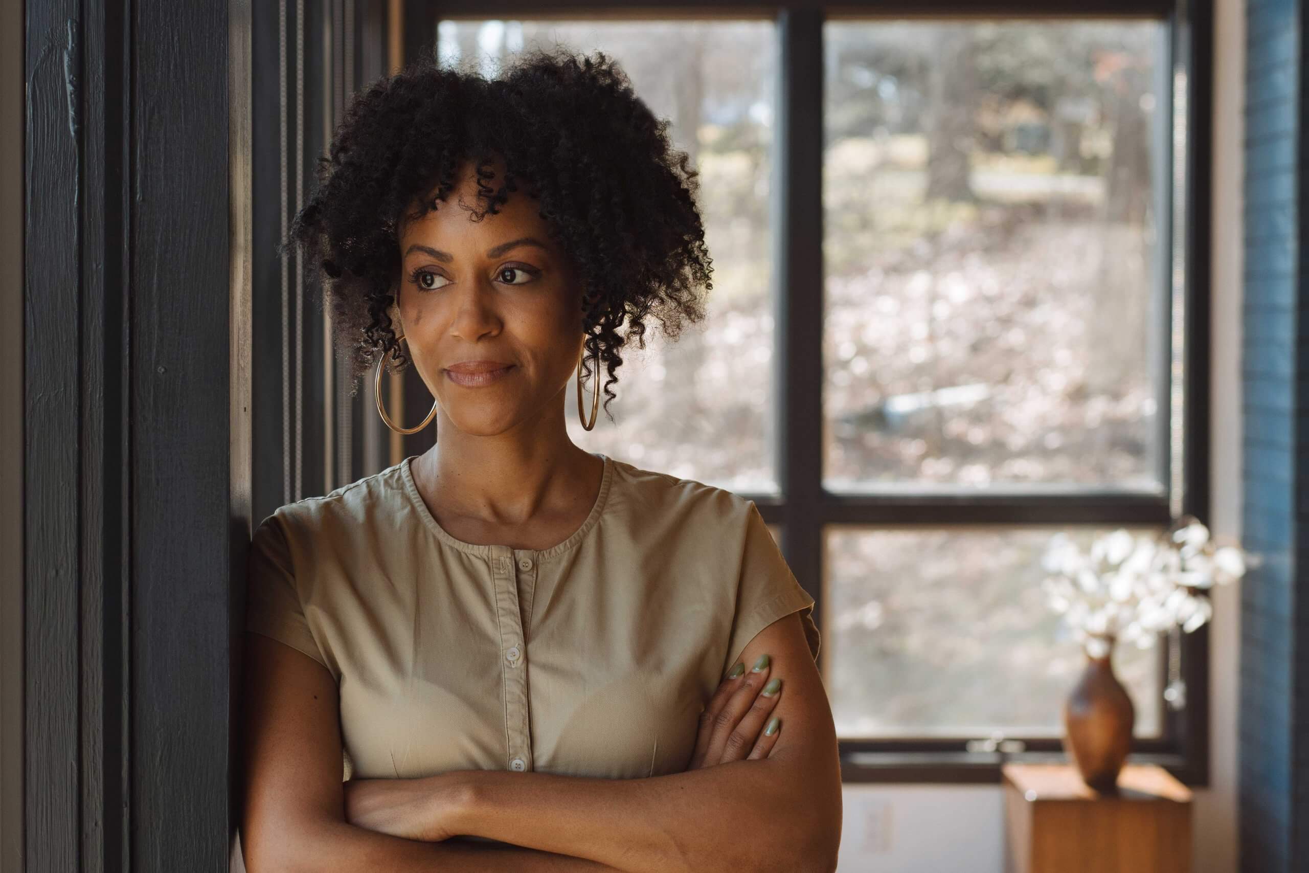 Portrait of Nailah Jefferson. Nailah looks away from camera with arms crossed.