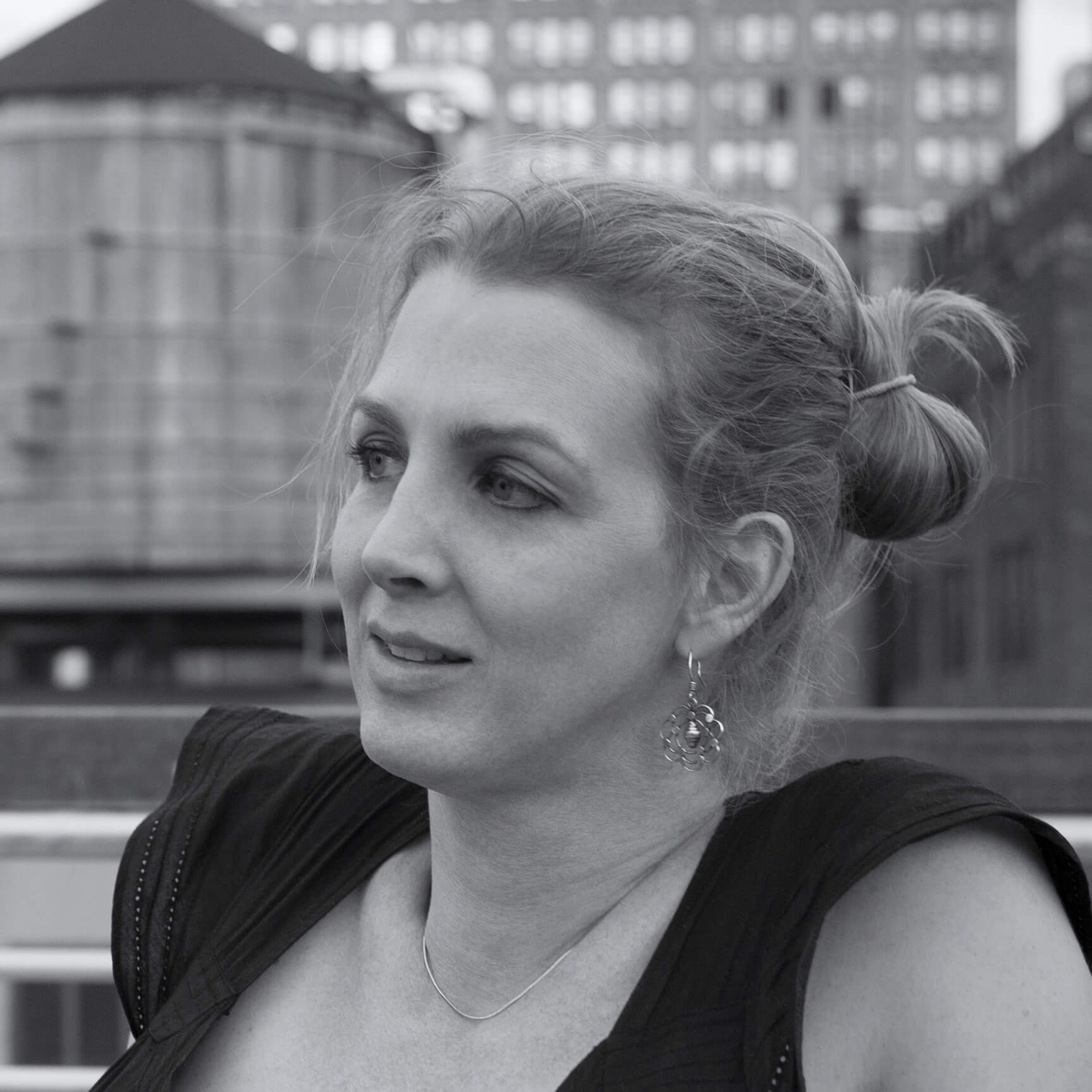 Kimberly Reed profile, with light hair in a bun, wearing a dark blouse