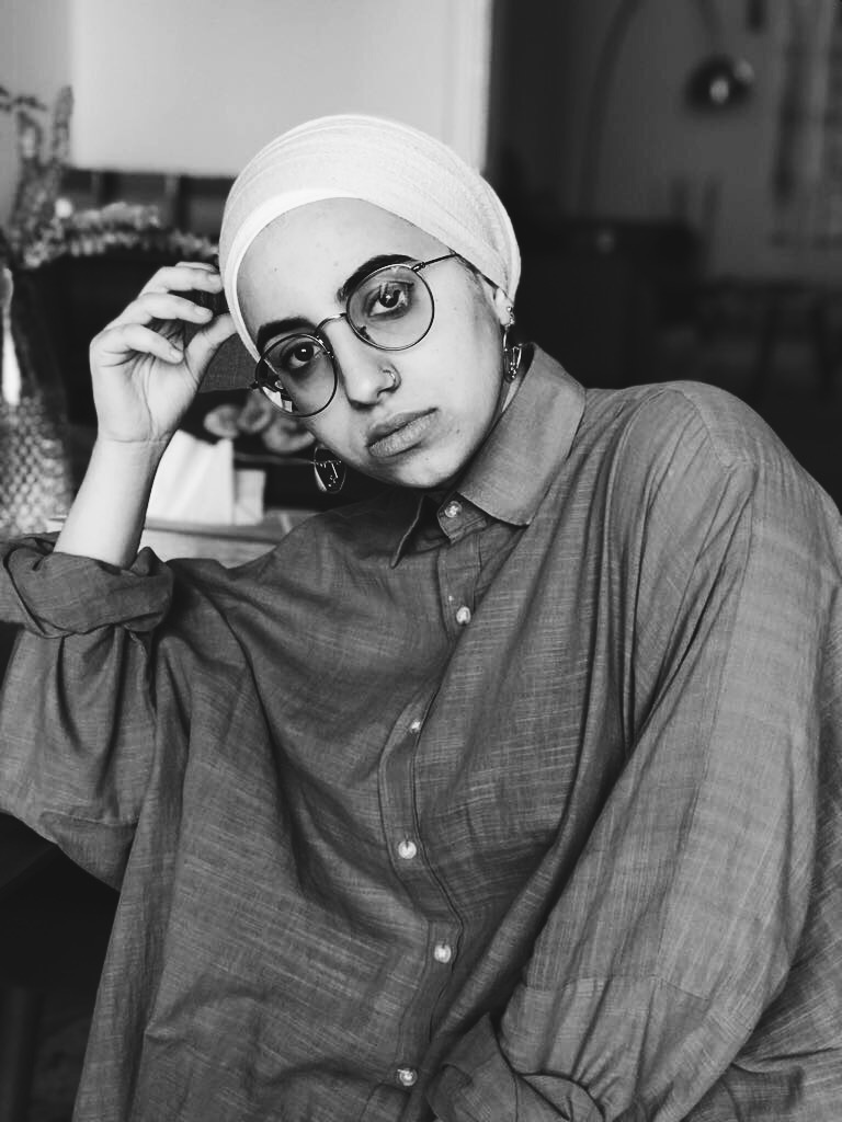 Jude Chehab looks at the camera, her right hand touching her head. Black and white portrait.