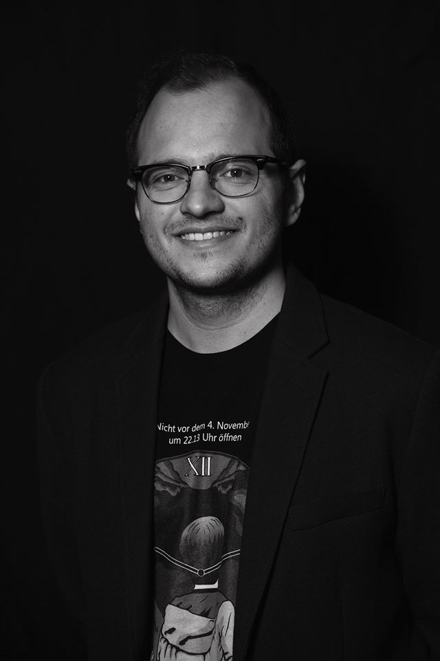 Gábor Osváth looks directly at the camera and smiles. Photo in black and white.