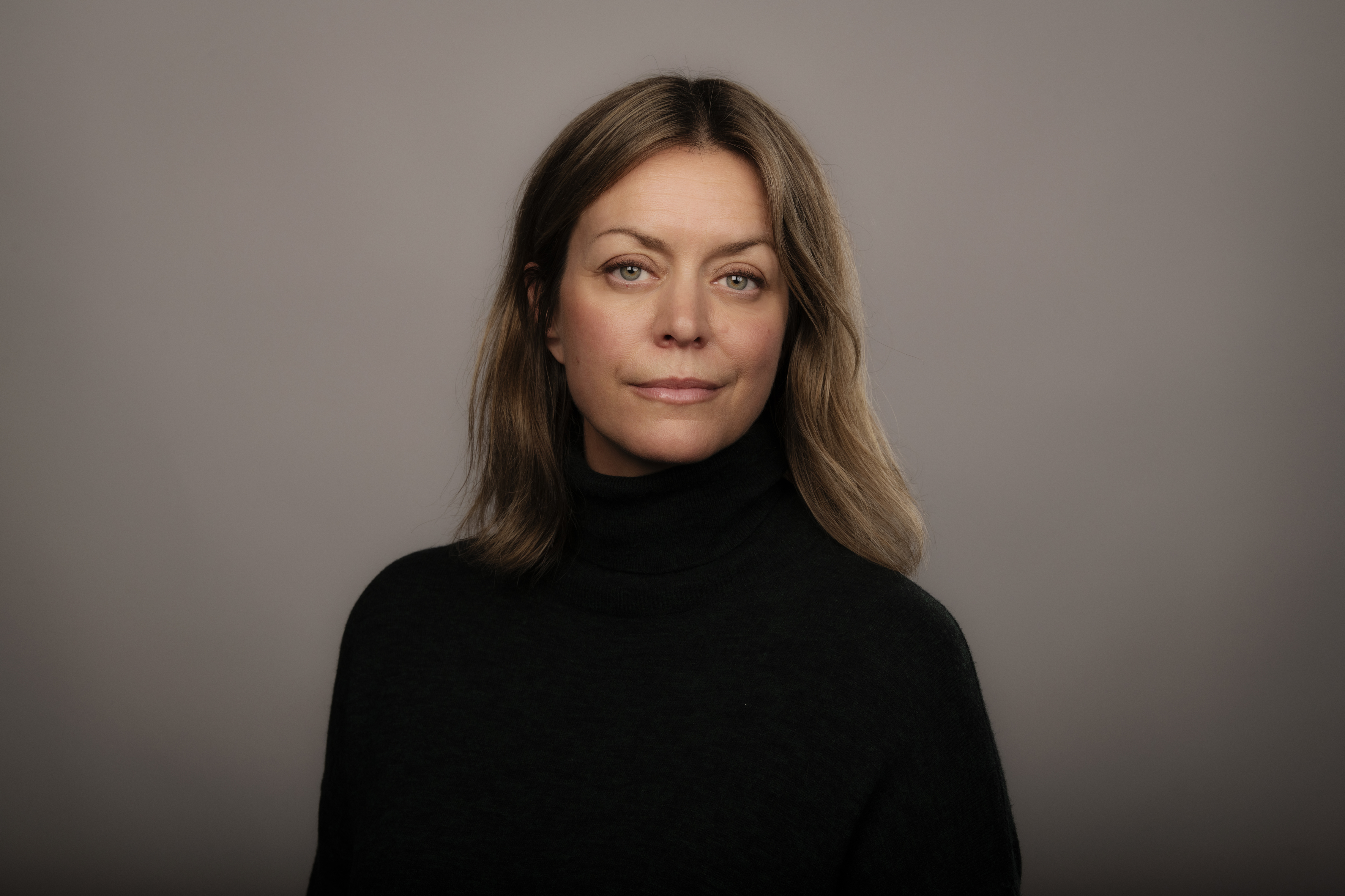 A portrait of Erika Malmgren against a grey background.