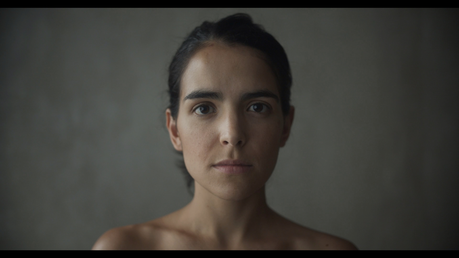 Headshot of a woman with dark hair and a ponytail looking at the camera