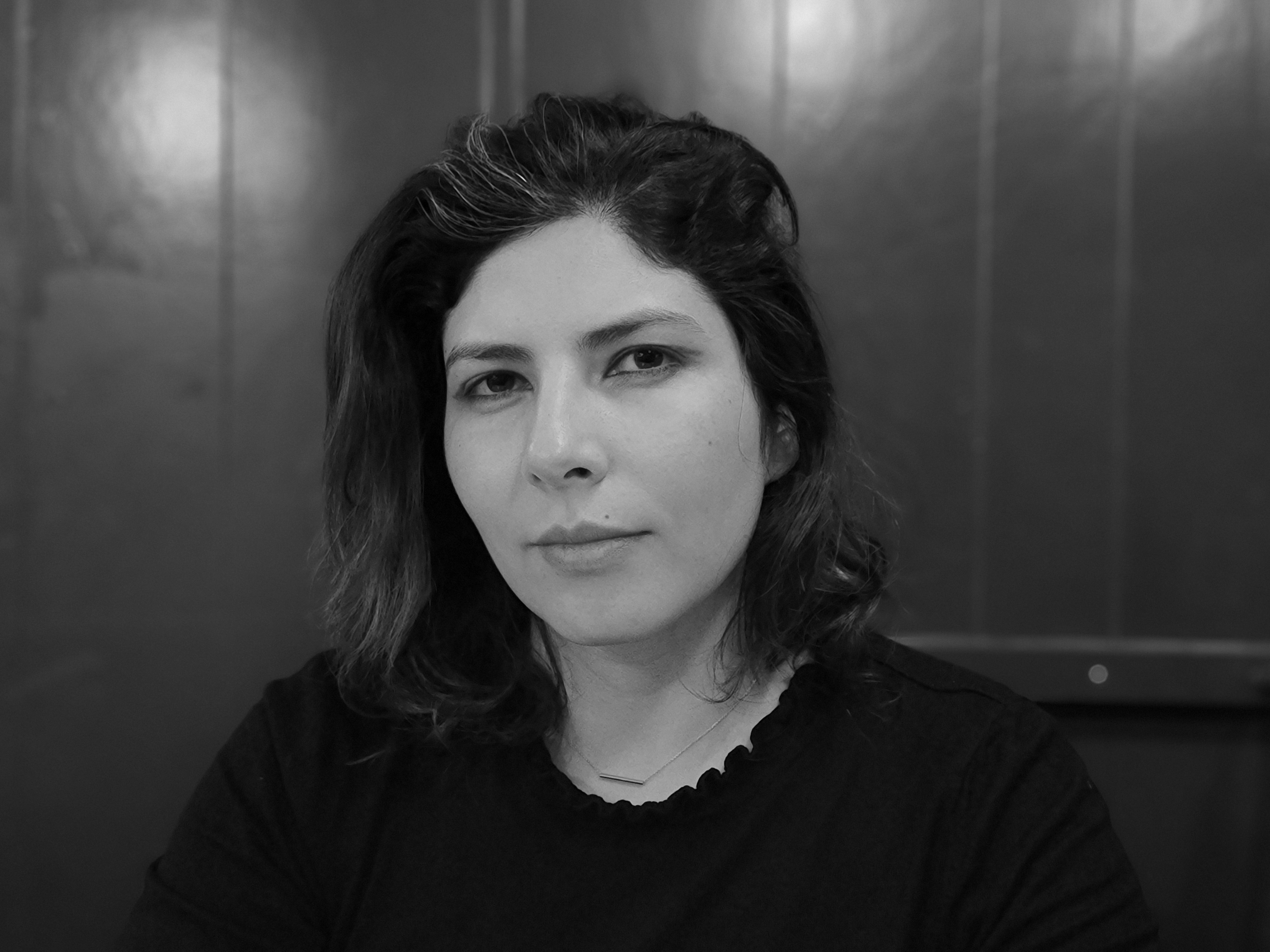 A black and white portrait of a woman with short hair looking into the camera.