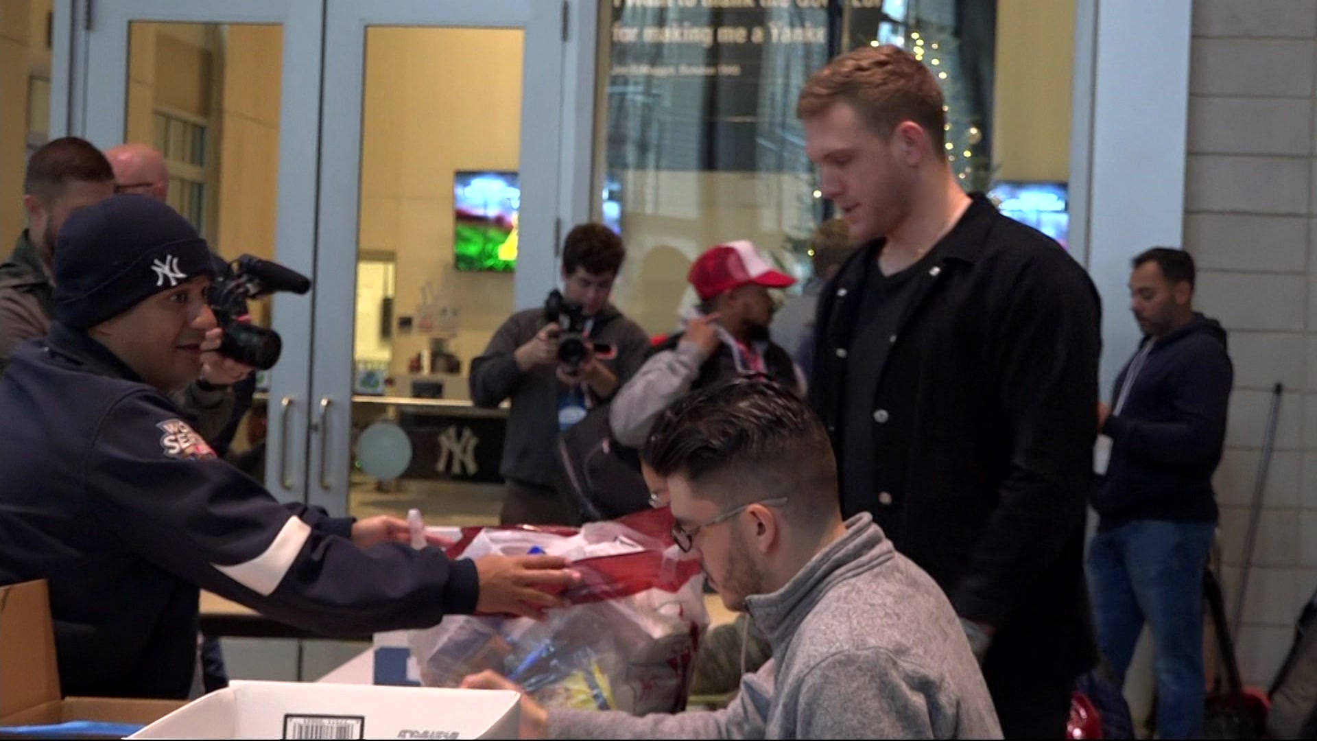 Fans pour into Yankee Stadium on rainy day to donate food