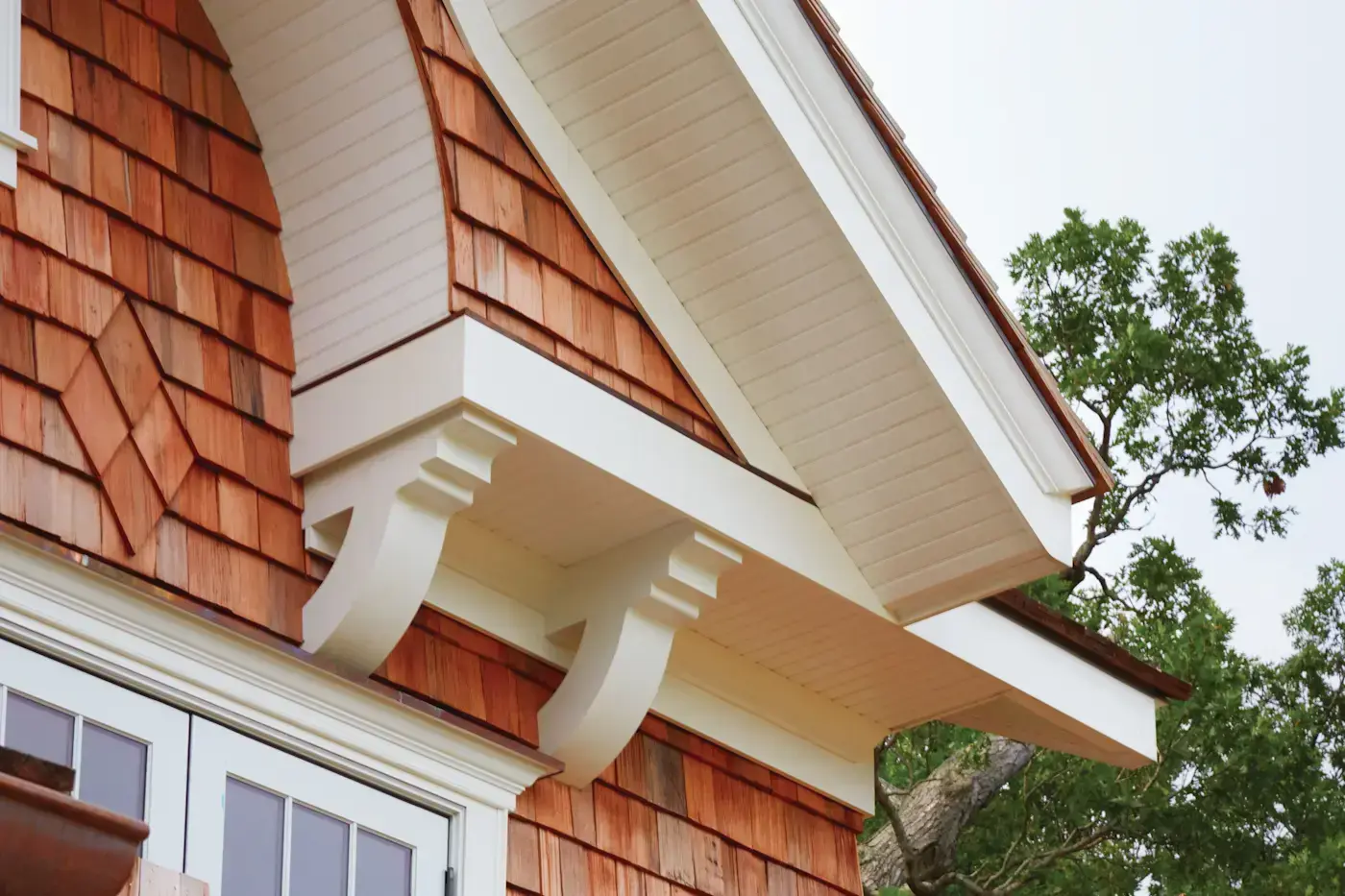 Elegant custom corbels crafted from solid cellular vinyl enhance the eaves of this home's exterior, adding both structural support and timeless architectural charm.