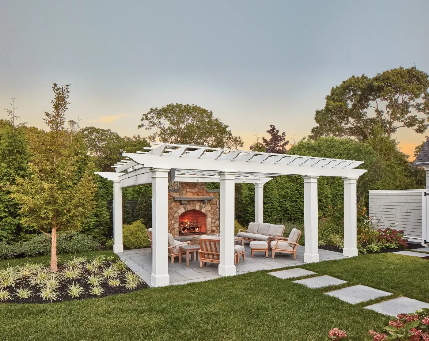 This custom pergola creates an additional outdoor living space set away from the home. Walpole custom creates pergolas that are the focal point for gathering, entertaining, and simply relaxing. Darien columns and a shade canopy complete the look for this home's backyard pergola.