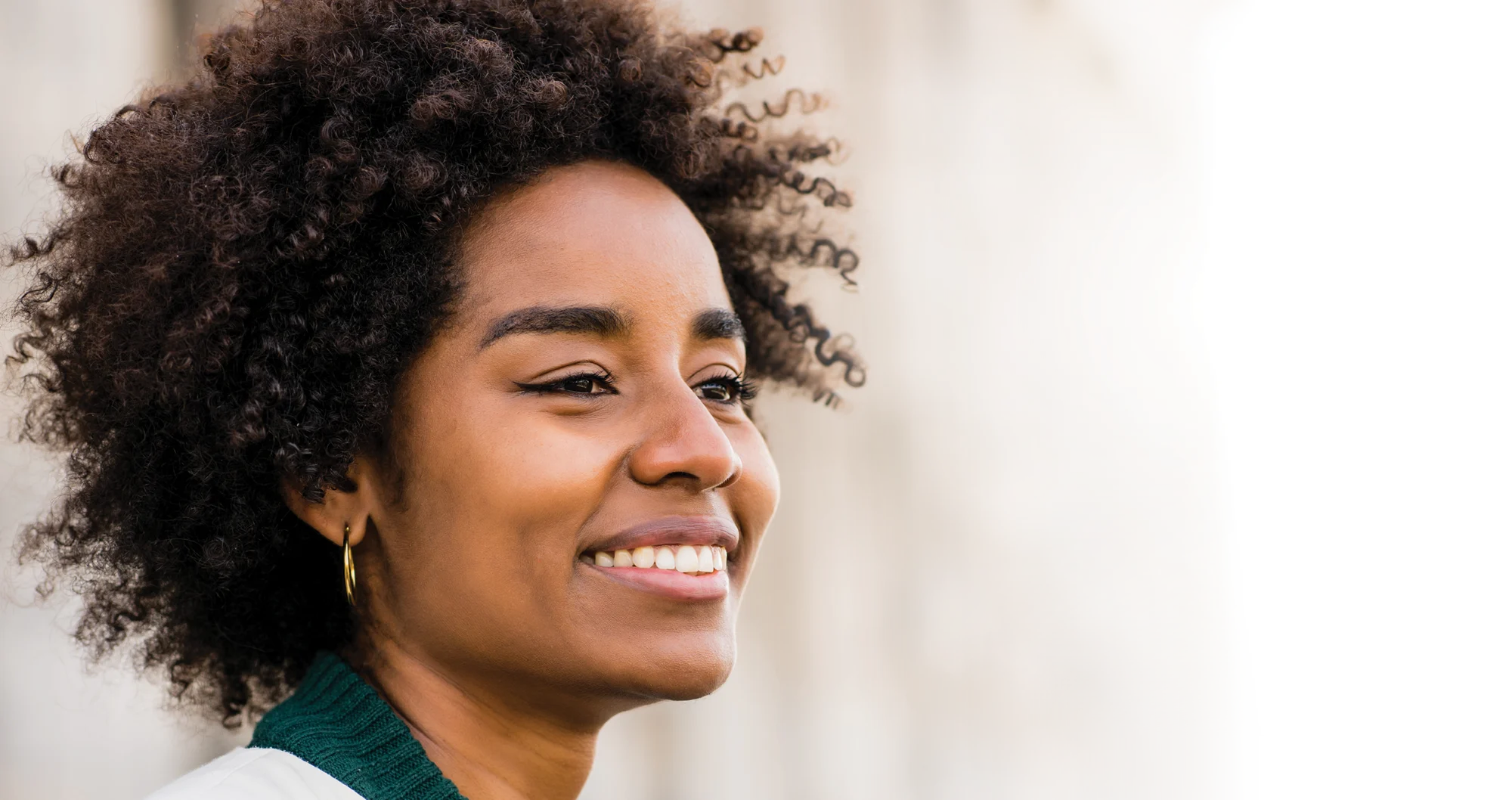 Close up of a woman smiling into the distance.