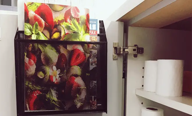 Un porte-revues est suspendu à l'intérieur d'une porte d'armoire de la salle de bain.