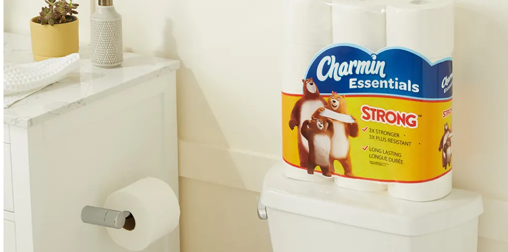 Un emballage de Charmin Essentials Strong est posé sur une toilette.