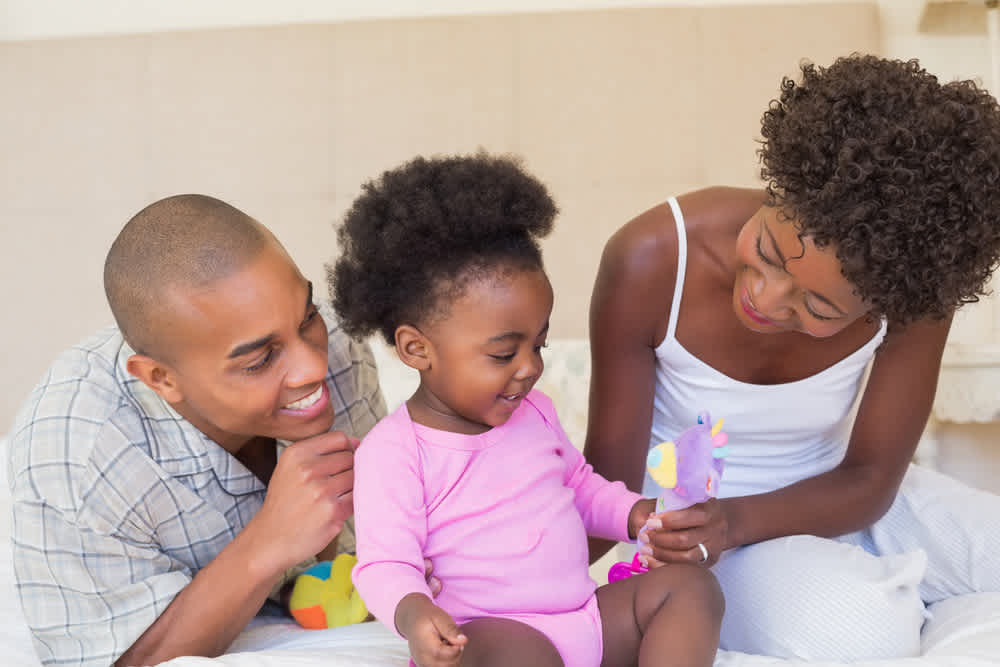 Mom and dad playing with daughter