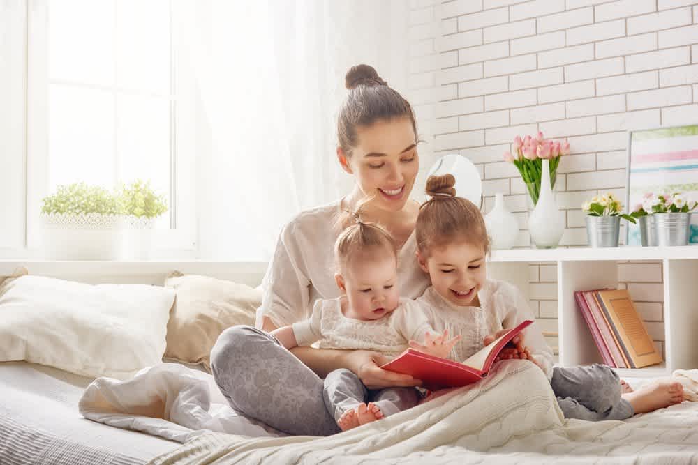 Mother reading to daughters