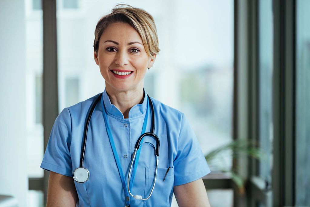 portrait-smiling-nurse-looking-camera-while-standing-clinic.jpg