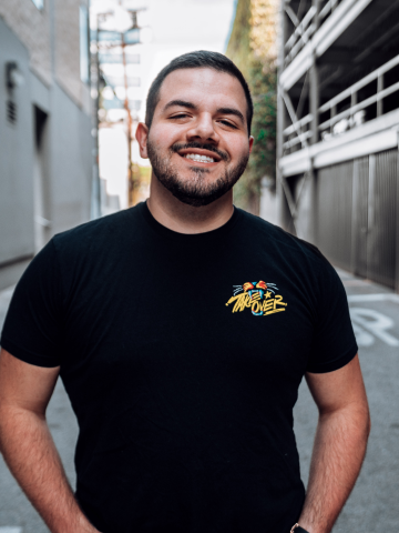 CouRageJD posing in city alleyway