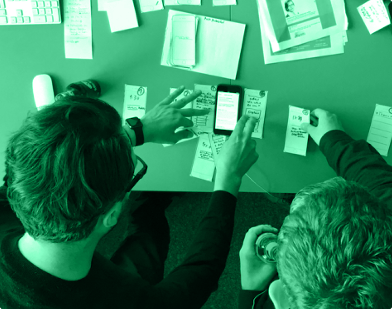 Designers working and sketching ideas using phones and paper