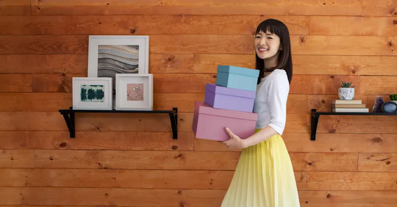 A woman holding three boxes.
