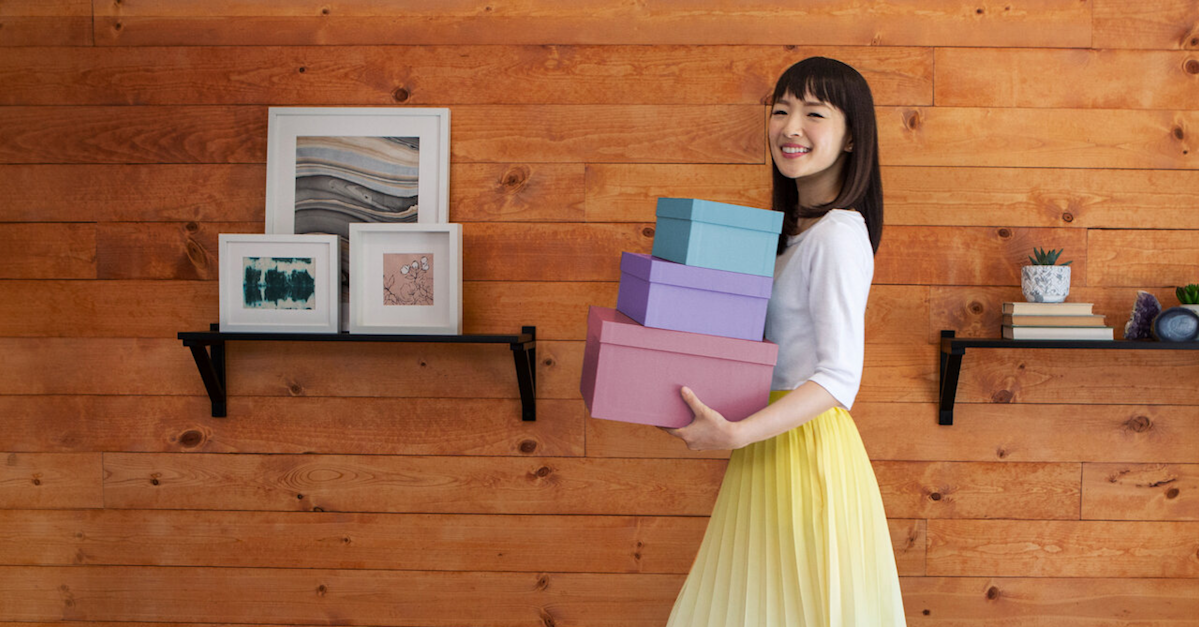 A woman holding three boxes.