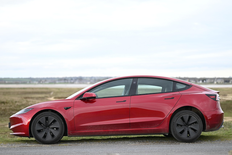 A side profile of a red Tesla Model Y, an electric vehicle that averages $2,800 for comprehensive insurance in 2026—approximately 40% higher than comparable petrol SUVs, making a Quashed Market Scan essential before purchasing.