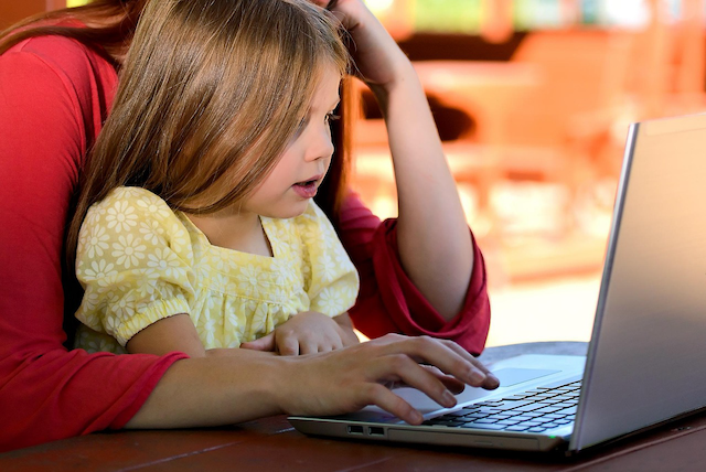 A New Zealand mother and daughter reviewing car insurance documents together on a laptop, representing the informed approach to comparing Trade Me listing prices and insurance valuations that Quashed empowers in this 2026 guide.