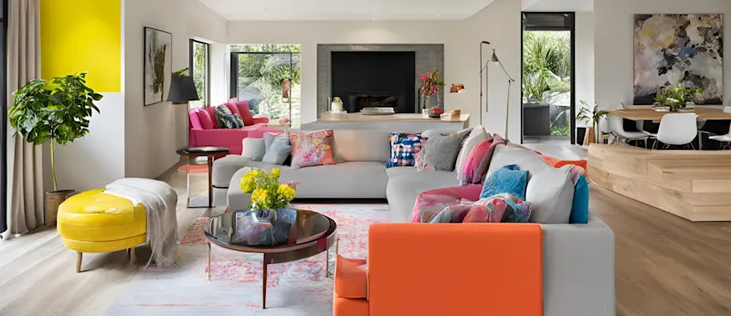 A modern living room with bright natural lighting and light wooden flooring and amenities.
